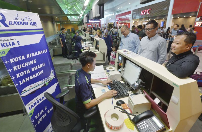 Petugas syarikat penerbangan Rayani Air menyelesaikan urusan daftar masuk para penumpang pada hari pertama penerbangan Rayani Air RN0600 ke Langkawi di Lapangan Terbang Antarabangsa Kuala Lumpur 2 (KLIA2) 20 Dis 2015. u00e2u20acu201d Foto Bernama 