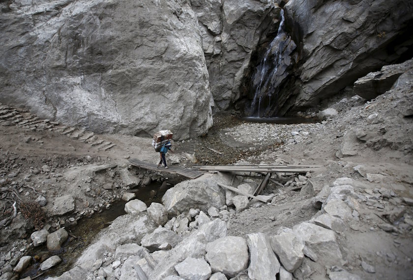 A porter carrying goods walks along the landslide affected area that occurred during the earthquake earlier this year in Solukhumbu district, also known as the Everest region, in this picture taken November 28, 2015. — Reuters pic