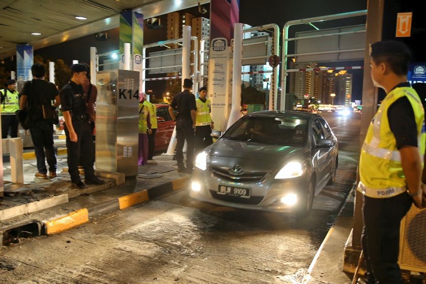 Police keep an eye on proceedings during the #ShutdownSungaiBesi rally near the Sungai Besi toll plaza, Kuala Lumpur, on January 1, 2016. u00e2u20acu201d  Picture by Saw Siow Feng