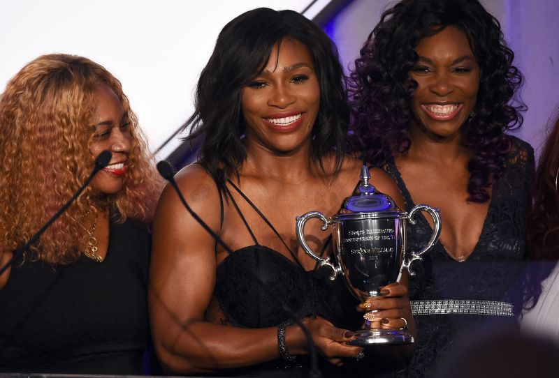US tennis player Serena Williams (C) receives the Sports Illustrated Sportsperson of the Year trophy from her sister Venus Williams as their mother Oracene Price (L) looks on during a ceremony in New York on December 15, 2015. AFP PHOTO/JEWEL SAMAD