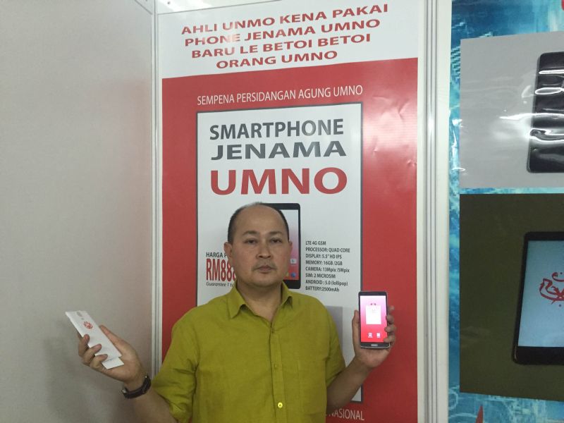 Chili Mobile founder Abdul Rahim Mohammad posing with the Umno smartphone at his booth. u00e2u20acu2022 Picture by Kamles Kumar