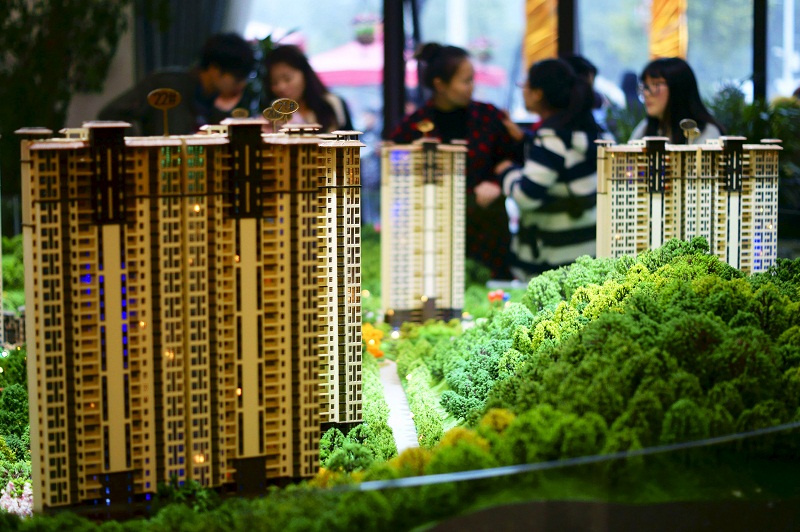 People look at miniature models of new apartments at a property sale centre in Yichang, Hubei province. u00e2u20acu201d Reuters pic