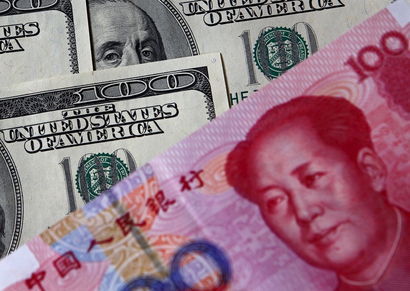 A 100 yuan banknote (bottom) is placed next to US US$100 banknotes in this picture illustration taken in Beijing, in this November 1, 2010 file photo. u00e2u20acu201d Reuters pic