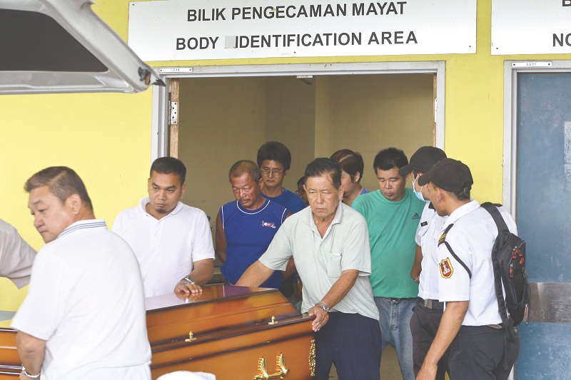Zi Xinu00e2u20acu2122s casket being brought out by her father Wai Tin (in blue), accompanied by Lin Cheong Sun (behind him). u00e2u20acu201d Picture by Azneal Ishak