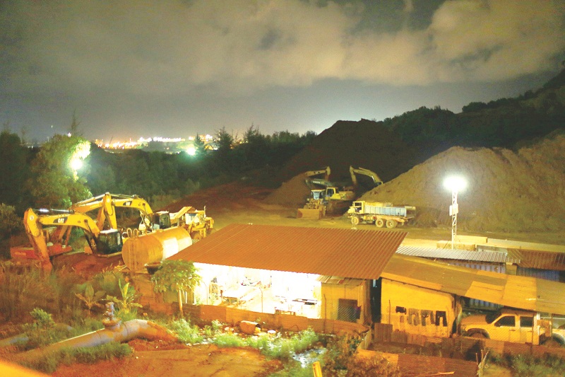 Excavators and lorries scramble to clear the ore stockpile at Kuantan Port before the moratorium is implemented. u00e2u20acu201d Picture by Ahmad Zamzahuri