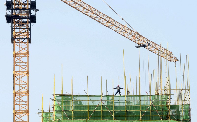 A labourer walks on scaffolding at a residential construction site in Qingdao, Shandong province, China, November 18, 2015. u00e2u20acu201d Reuters pic