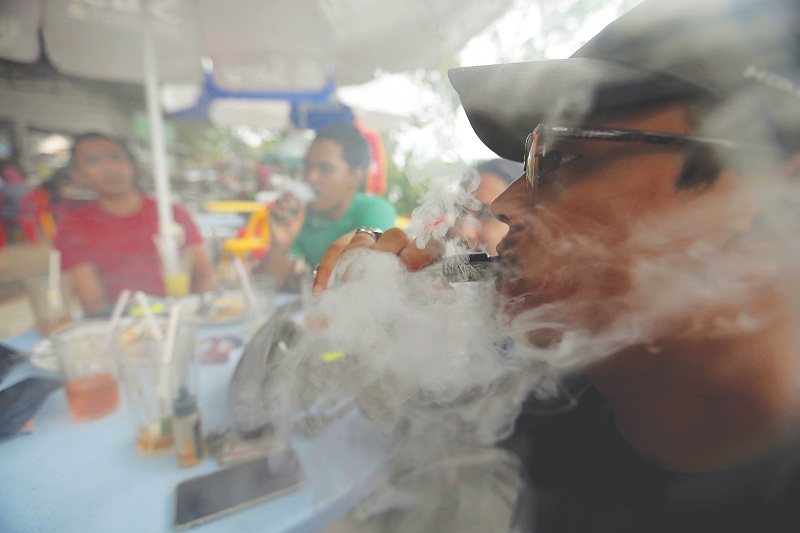 A group of youths vaping at a restaurant in Canning Garden, Ipoh. Perak will no longer issue licence to sell e-cigarette and vape products. u00e2u20acu201d Picture by Farhan Najib Yusoff
