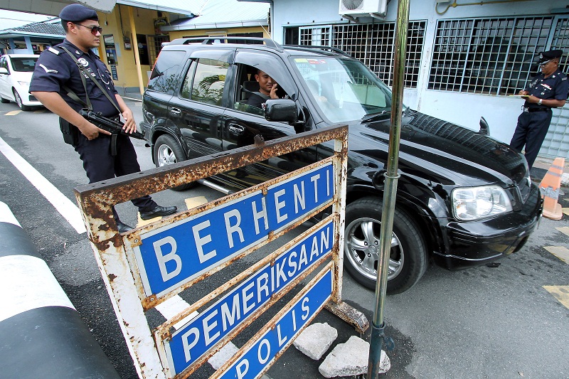Police personnel check the identification of a driver at the Malaysia-Thailand border at the Padang Besar checkpoint in Kedah January 18, 2016. u00e2u20acu201d Bernama pic