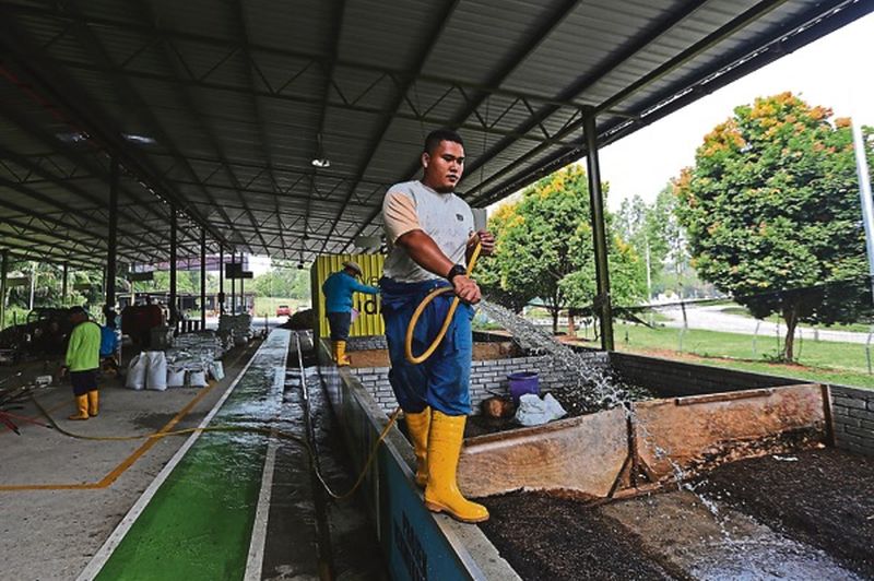A council staff manning a compost box at the centre. u00e2u20acu201d Picture by Azneal Ishak