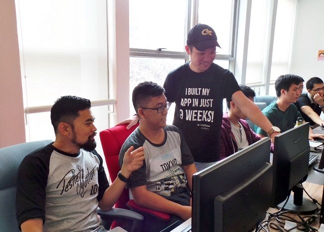 NEXT Academy cofounder and CEO Josh Teng (standing) with some of this students. u00e2u20acu201d DNA pic