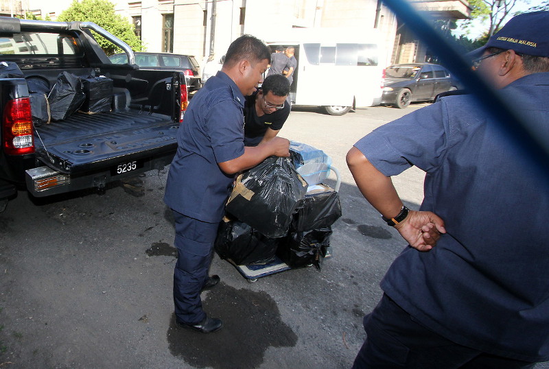 Customs officers carry evidence of marijuana weighing 99 kilograms to the Kangar Magistrate's Court Jan 11, 2016. u00e2u20acu201d Bernama pic