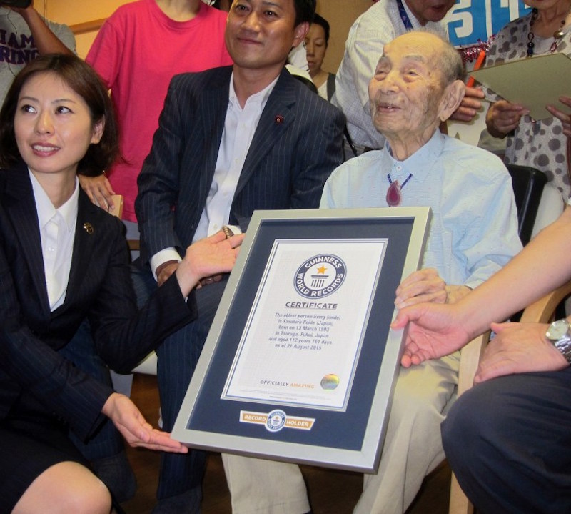 The worldu00e2u20acu2122s oldest man, 112-year-old Yasutaro Koide (right), receives a framed certificate from the Guinness World Records as the worldu00e2u20acu2122s oldest man, in Nagoya, Aichi prefecture in central Japan August 21, 2015. u00e2u20acu201d AFP pic