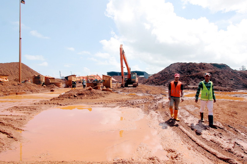 Two employees walking in the bauxite reserve area at Kuantan Port without wearing protective mask, January 6, 2016.  u00e2u20acu201d Bernama pic