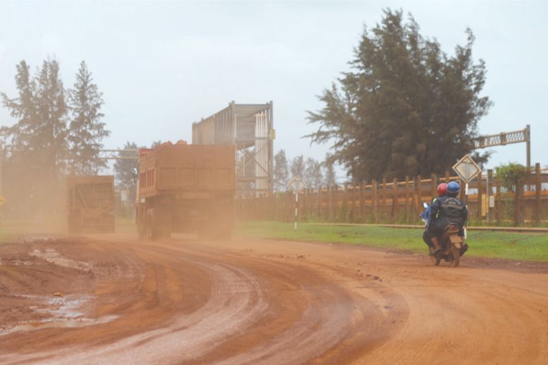Layers of red dust cover the road and lorries entering a bauxite collection centre in Kuantan Port. u00e2u20acu201d Picture by Ahmad Zamzahuri
