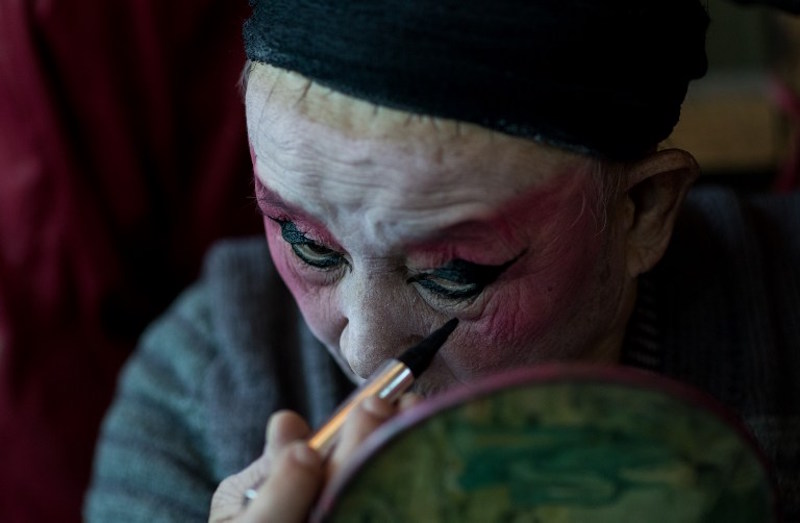 This picture taken on January 7, 2016 in Kunming shows He Zhengcai, director of the u00e2u20acu02dcFlower Lanternu00e2u20acu2122 troupe, putting on his makeup backstage before a show. u00e2u20acu201d AFP pic