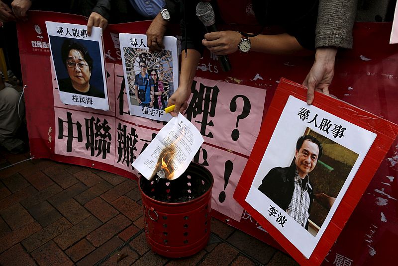 A pro-democracy demonstrator burns a letter next to pictures of (from left) Gui Minhai, Cheung Jiping, and Lee Bo during a protest to call for an investigation behind their disappearance in Hong Kong, China January 3, 2016. u00e2u20acu201d Reuters pic
