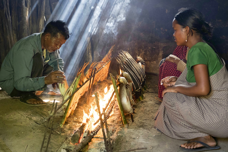 Fish are smoked for several hours beside the fire in the rural village of Umladkhur. — Picture by Carla Capalbo/Zester Daily via Reuters