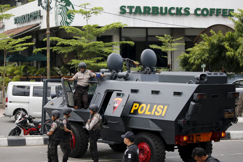 Indonesian policemen with weapons and an armoured vehicle guard in front of a Starbuck cafe at Thamrin business district in Jakarta, January 14, 2016. u00e2u20acu201d Reuters pic