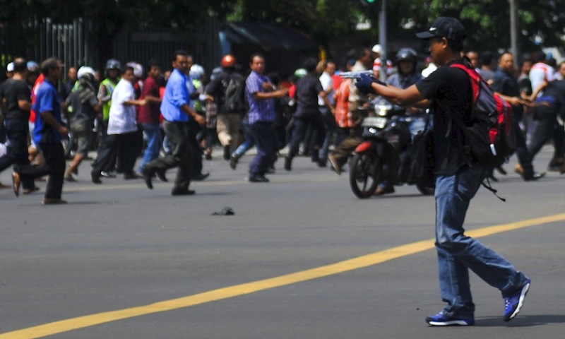 A man is seen holding a gun towards the crowd in central Jakarta, Indonesia, in this picture provided to Reuters by Xinhua News Agency January 14, 2016.  u00e2u20acu201d Reuters pic