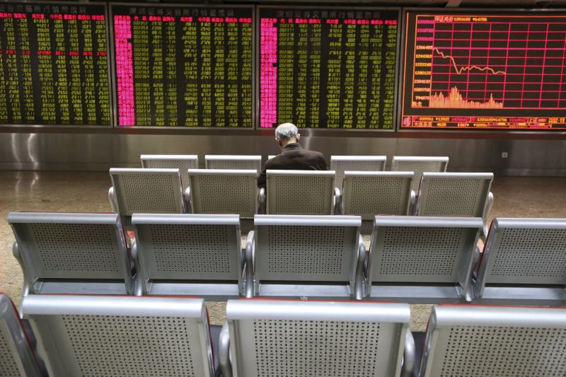 An investor sits in front of an electronic board showing stock information at a brokerage house in Beijing, January 4, 2016. REUTERS/Li Sanxian