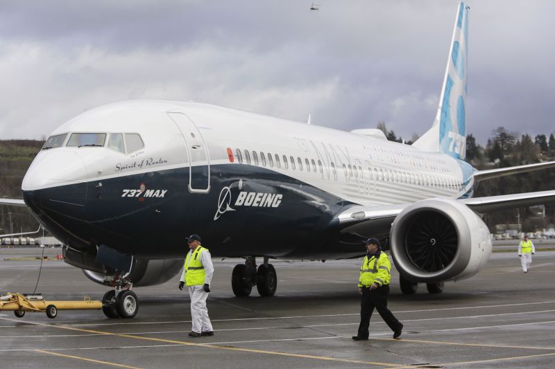Ground crew members escort a Boeing 737 MAX as it returns from a flight test at Boeing Field in Seattle, Washington, January 29, 2016. REUTERS/Jason Redmond