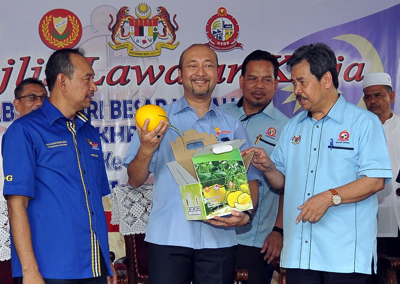 Kedah Menteri Besar Datuk Seri Mukhriz Tun Mahathir (second left) shows the Golden Melon fruit, a product of the Kedah Regional Development Authority (Keda) after opening the Keda Wang Tepus village council near Jan, Kedah, Jan 18, 2016. u00e2u20acu201d Bernma pic