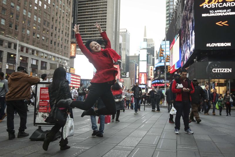 A tourist jumps in the air as she poses for a photo in Times Square, New York. u00e2u20acu2022 Reuters pic