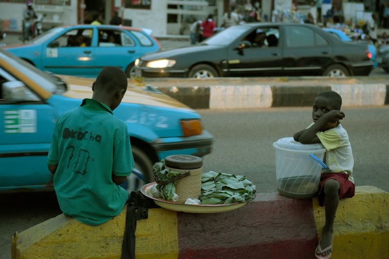 Two children sit on the pavement along the road at night to hawk their wares in Akure, Ondo State in southwestern Nigeria, on March 24, 2015. u00e2u20acu201d AFP pic
