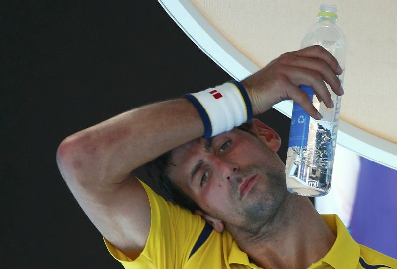 Serbia's Novak Djokovic wipes his forehead as he drinks water during his first round match against South Korea's Hyeon Chung at the Australian Open. u00e2u20acu201d Reuters pic