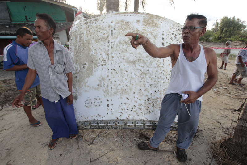 People stand next to a piece of suspected plane wreckage that has been found off the coast of southern Thailand in Nakhon Si Thammarat province, January 24, 2016. u00e2u20acu201d Reuters pic