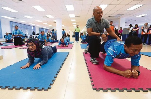 Health Ministry director Datuk Dr Narimah Nor Yahaya and PDRM Management director Datuk Zulkifli Abdullah stretch at the Trim N Fit course at Pulapol. u00e2u20acu201d Picture by Zuraneeza Zulkifli
