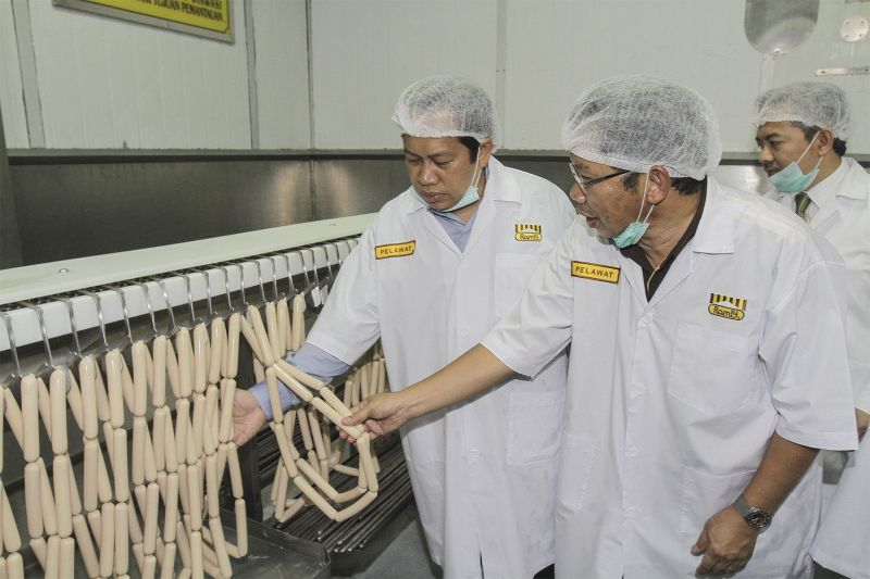 Datuk Ramly Mokni gives Datuk Ahmad Maslan (left) a tour of the Ramly Food Processing Centre in Kuala Lumpur, January 13, 2016.