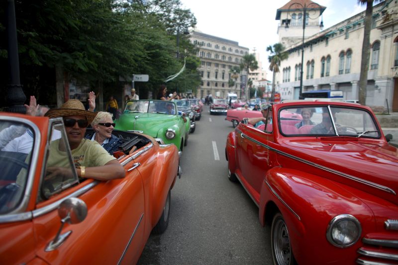 Tourists enjoy a ride in vintage cars in old Havana in this January 17, 2016 picture. REUTERS/Alexandre Meneghini