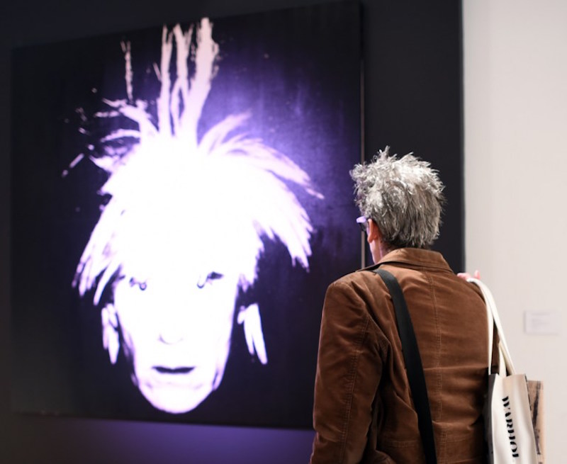 A reporter looks at Andy Warholu00e2u20acu2122s u00e2u20acu02dcSelf-Portraitu00e2u20acu2122 during a media preview at Christieu00e2u20acu2122s in New York October 31, 2014. u00e2u20acu201d AFP pic