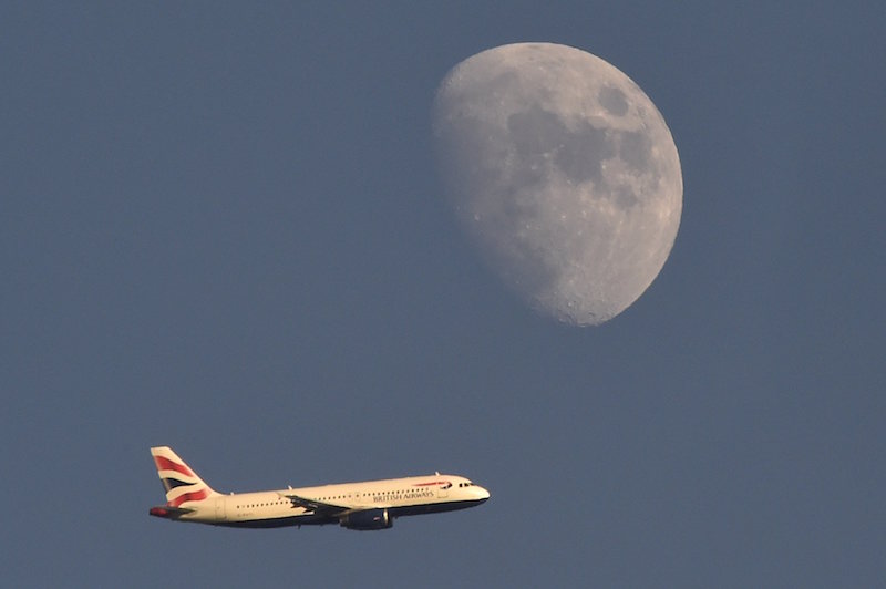 A British Airways passenger plane flies in the sky with the moon seen in the background, in London January 19, 2016. u00e2u20acu201d Reuters pic