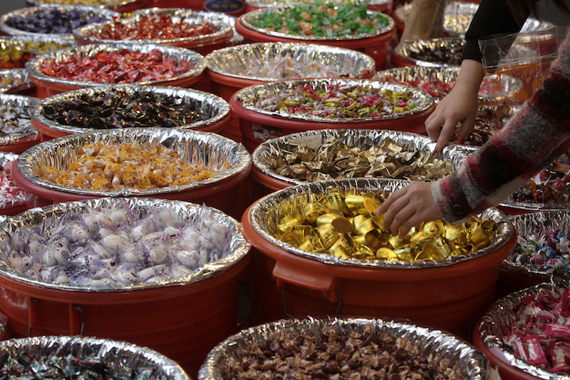 People pick up candies in a shop selling Chinese New Year goods at a market in Taipei February 3, 2016. u00e2u20acu201d Reuters pic