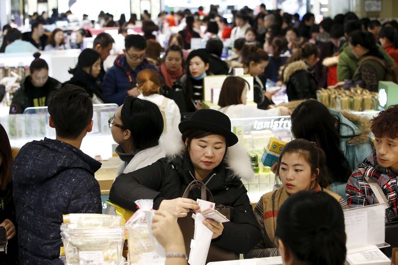 A Chinese tourist pays cash at a Lotte duty free shop in central Seoul February 2, 2016. — Reuters pic