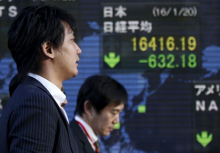 Men walk past an electronic board showing Japanu00e2u20acu2122s Nikkei average outside a brokerage in Tokyo, Japan February 8, 2016. u00e2u20acu201d Reuters pic