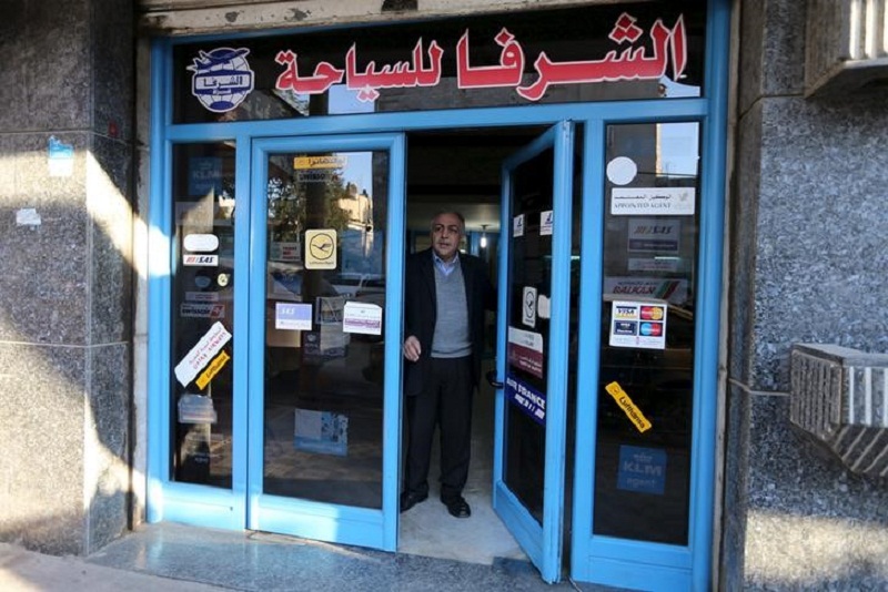 Palestinian travel agent Nabil Shurafa stands at the entrance of his office in Gaza City.