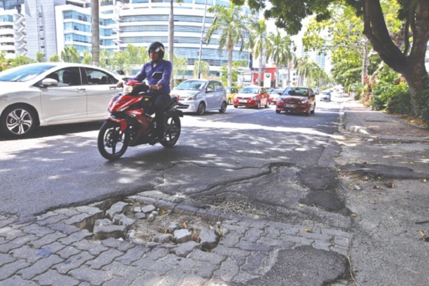 The Works Ministry says completely eradicating pot holes would not be possible. u00e2u20acu201d Picture by Azneal Ishak