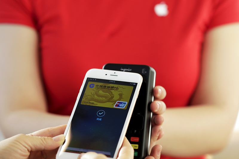 Employees use an Apple iPhone to demonstrate to reporters how to pay using Apple Pay service at an Apple store in Beijing on February 17, 2016. u00e2u20acu201d Reuters pic