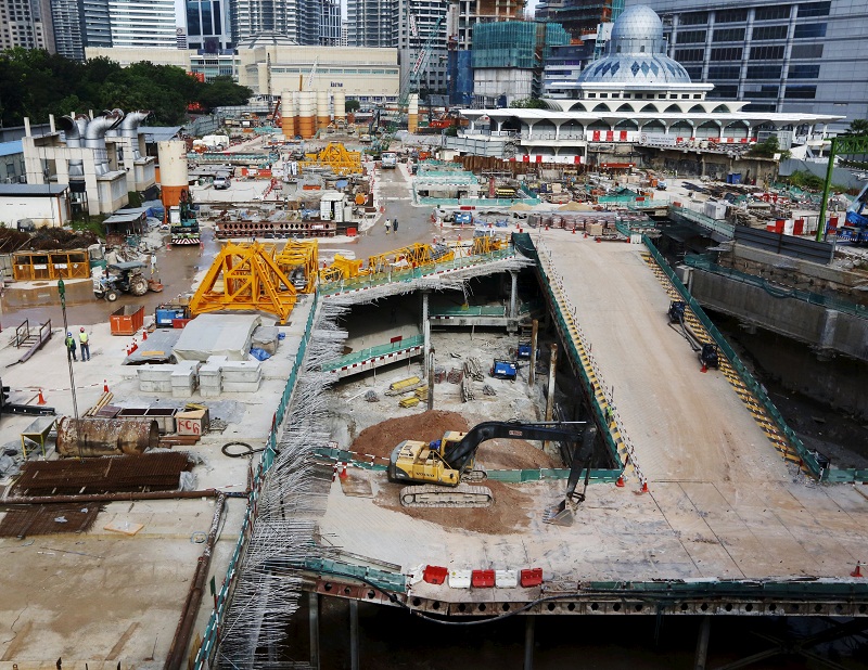 Workmen at a building site next to a mosque in Kuala Lumpur on February 18, 2016. u00e2u20acu201d Reuters pic