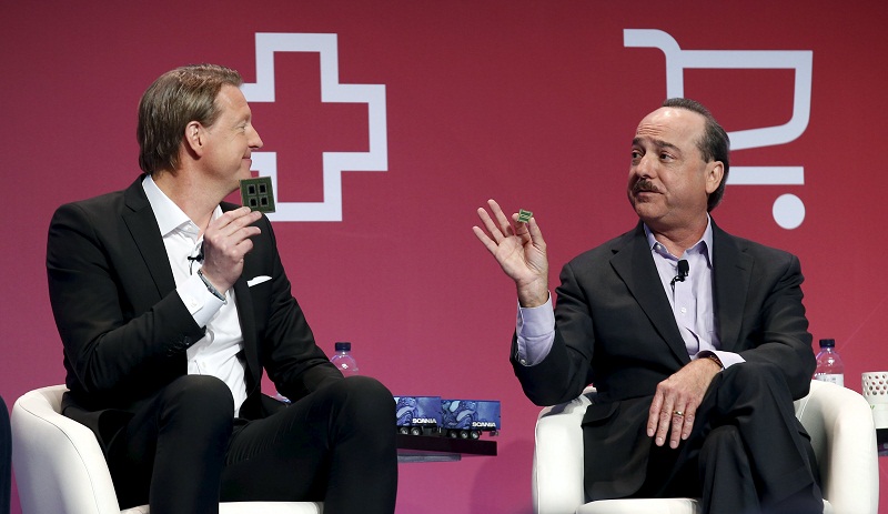 Ericssonu00e2u20acu2122s President & CEO Hans Vestberg (left) shows a 5G chip as he jokes with Ralph de la Vega, Vice Chairman of AT&T Inc and CEO of AT&T Business Solutions and AT&T International, during the Mobile World Congress in Barcelona, Spain February 23, 201