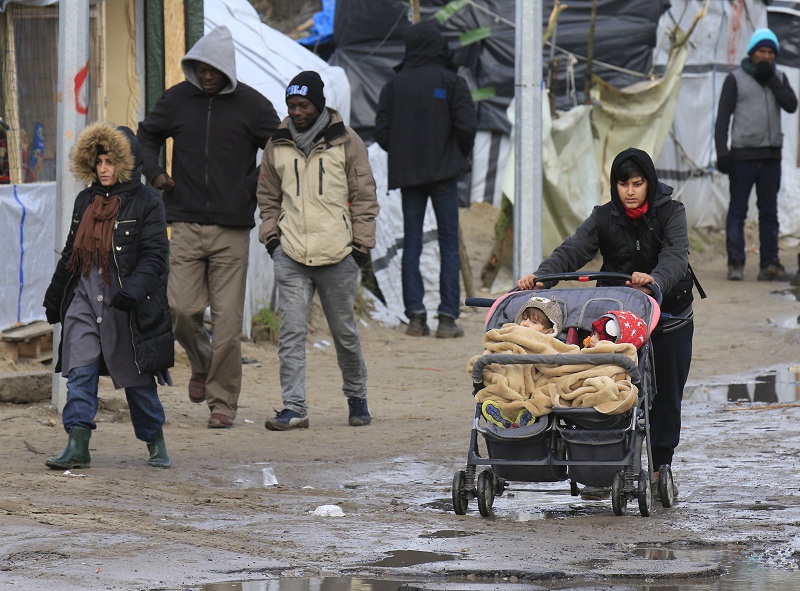 A Kurdish migrant pushes a pram with her two children through a muddy area in the southern part of a camp for migrants called the u00e2u20acu02dcjungleu00e2u20acu2122, in Calais, northern France on February 25, 2016. u00e2u20acu201d Reuters pic