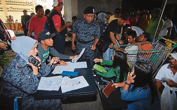 Penang Immigration Department deputy director Abdul Rahman Hassan checks on foreigners during an operation in Bukit Mertajam yesterday. u00e2u20acu201dBernama pic