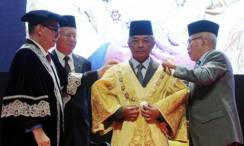 Tengku Mahkota of Pahang Tengku Abdullah Sultan Ahmad Shah puts on the robe of the Chancellor of DRB-HICOM University of Automotive Malaysia, in Pekan, witnessed by Prime Minister Datuk Seri Najib Razak (second left) Feb 21, 2016. u00e2u20acu201d Bernama pic