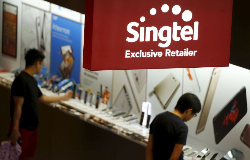 People look at mobile handsets at a Singtel retailer shop in Singapore February 13, 2016. u00e2u20acu201d Reuters pic
