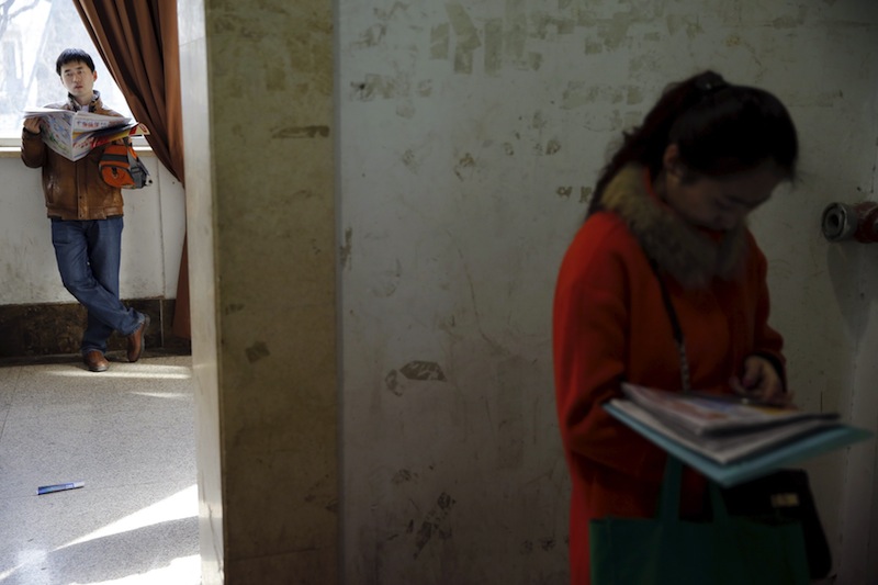 A man reads newspapers advertising jobs as recruiters and job seekers gather at a job fair in Beijing, China February 28, 2016. u00e2u20acu201d Reuters pic