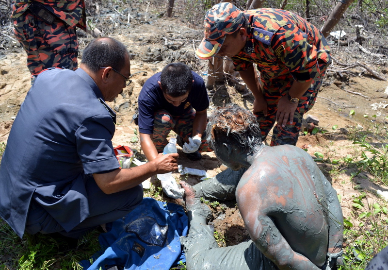 The Indonesian illegal immigrant (right) was rescued by the Kubu Fire and Rescue Department after he spent two hours trapped in mud at Pulau Melaka February 16, 2016. u00e2u20acu201d Bernama pic