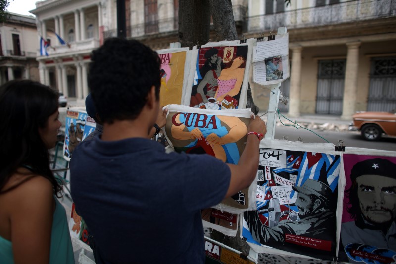 Tourists from Colombia look at posters in a street arts fair in Havana, February 20, 2016. u00e2u20acu201d Reuters pic